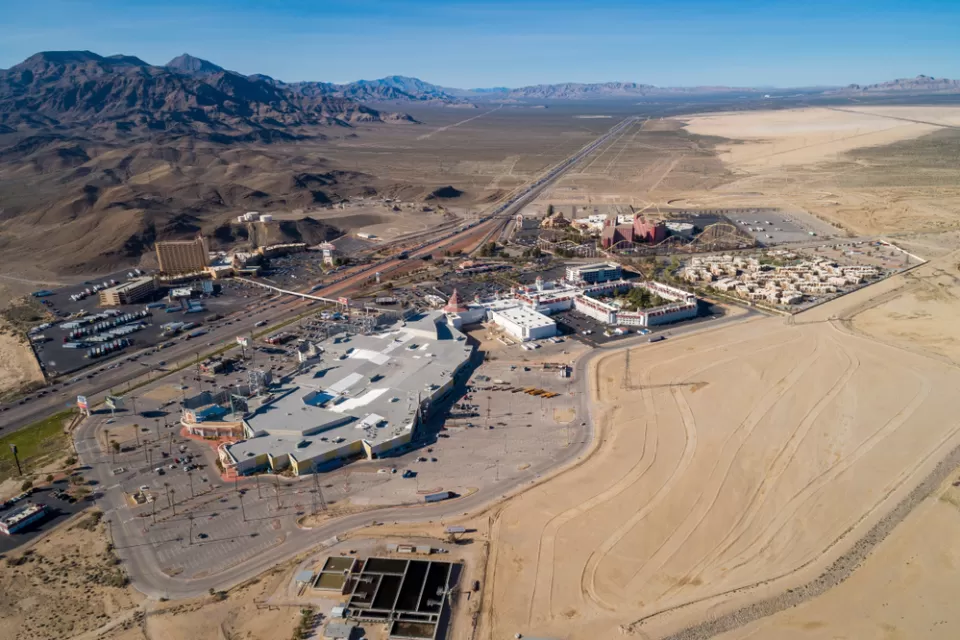 A aerical view of primm, Nevada, where I-15 bisects large casinos and parking lots on a sunny day.
